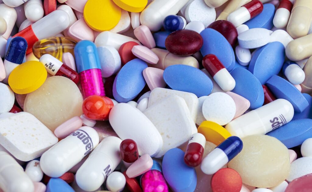 Executiva em reunião de estratégia de marcas farmacêuticas, com gráficos ao fundo.