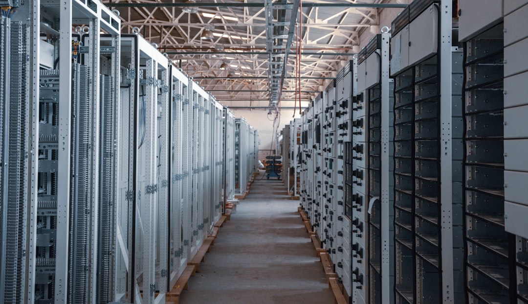 Corredor de data center com servidores iluminados em azul, representando infraestrutura de dados proprietários